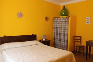 sypialnia z łóżkiem i wazą na ścianie w obiekcie Il Casale w mieście Poggibonsi