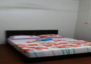 a bed with a colorful comforter on top of it at Batu Berendam Homestay in Melaka