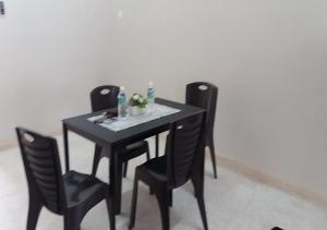a table with three chairs and a black table and chairs at Batu Berendam Homestay in Melaka