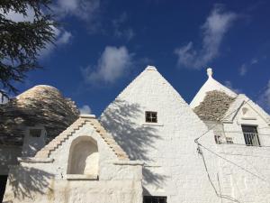 een wit gebouw met een dak met een blauwe lucht bij Fatuaria in Cisternino