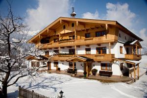 ein großes Holzgebäude mit Schnee auf dem Boden in der Unterkunft Larchergut in Mayrhofen