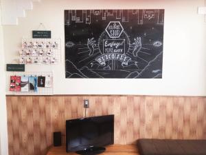 a drawing on a wall above a tv in a room at Guest House Kutomare in Kure