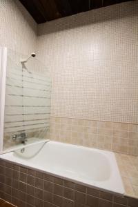 a bath tub in a bathroom with a tiled wall at El Tirol in Cantagallo