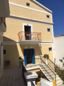 a building with stairs and a blue door and a balcony at Anastasia Hotel in Symi