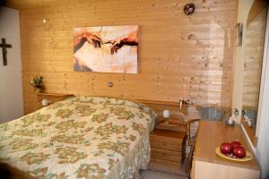 a bedroom with a bed and a wooden wall at Haus Moser in Wildensee