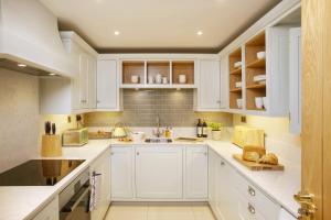 a white kitchen with white cabinets and a sink at The Hazel in Doolin