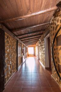 a hallway with stone walls and a wooden ceiling at El Tirol in Cantagallo