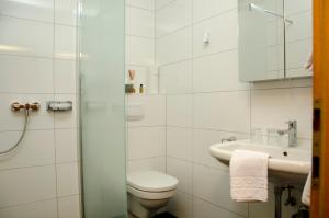 a white bathroom with a toilet and a sink at Gästehaus Schmidt in Podersdorf am See