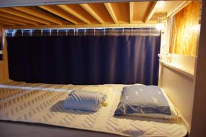 a bed in a room with a blue curtain at Guest House Kutomare in Kure