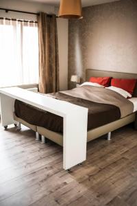 un letto bianco in una camera da letto con pavimento in legno di B&B A Dream City spa & Massages a Bruges