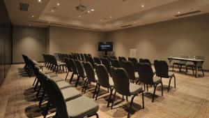 a room with chairs and a table and a tv at Pullman Dakar Teranga in Dakar +69 photos