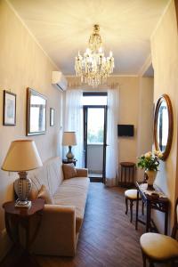 een woonkamer met een bank en een kroonluchter bij Fabio Guest House Deluxe in Rome