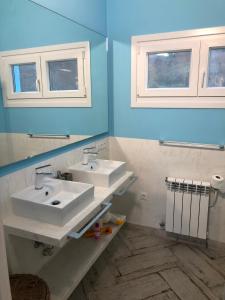 a bathroom with two sinks and two windows at Celtigos Beach Resort in Santa Marta de Ortigueira