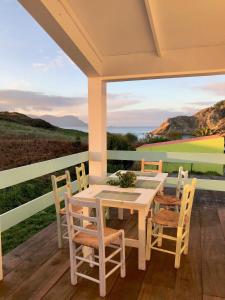 een tafel en stoelen op een veranda met uitzicht op de oceaan bij Celtigos Beach Resort in Santa Marta de Ortigueira