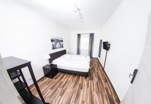a small bedroom with a bed on a wooden floor at Bedroom in Nuremberg