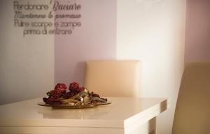 パルマにあるLa Casa di Ortensiaの白いテーブルの赤いバラの皿
