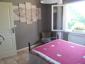 a bedroom with a pink bed and a window at Chambre Bel Air in Pimbo