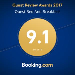 een bord dat queeste bed and breakfast met een gele cirkel leest bij Quest Bed And Breakfast in Melkbosstrand