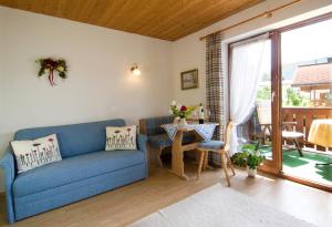 a living room with a blue couch and a table at Haus Christl Reit im Winkl, Kostenloser Parkplatz, Spülmaschine, 5 Minuten zum Ortszentrum, ruhige Lage, Wlan in Reit im Winkl