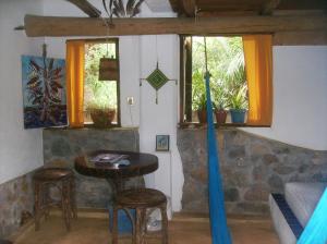 a room with a table and chairs and windows at Castillo Oasis in Zipolite