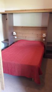 um quarto com uma cama vermelha e um cobertor vermelho em T2 RESIDENCE ANTARES 4* pieds des pistes em Risoul