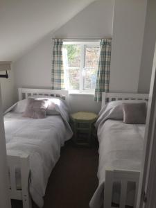 a bedroom with two beds and a window at The Annexe, Upper Rooksnest in Inkpen