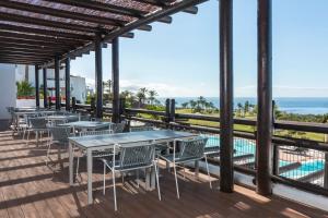 a patio with tables and chairs next to a pool at Las Terrazas de Abama Suites in Guía de Isora