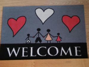 a welcome sign with a family with hearts on it at Ferienwohnung Helmis in Bad Frankenhausen