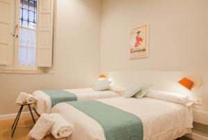 セビリアにあるMonumental Building Casa de la Moneda Center&Sweetの白と緑の部屋のベッド2台