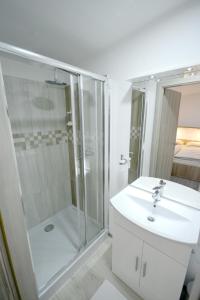 baño blanco con ducha y lavamanos en Evi Rooms Ljubljana, en Liubliana