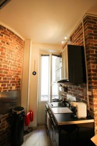 a kitchen with a stove and a brick wall at Apartment Boulevard Brune in Paris