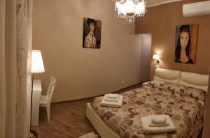 Fabio Guest House Deluxe في روما: غرفة نوم بسرير مع صورتين على الحائط