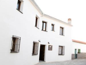 un edificio blanco con ventanas de barrotes en Casa Babel Monfragüe, en Torrejón el Rubio