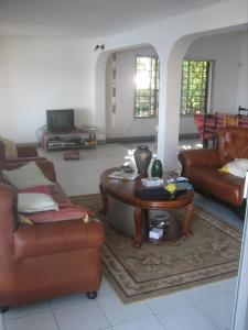 a living room with couches and a coffee table at Farida Lodge in Moroni
