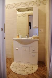 een badkamer met een wastafel en een spiegel bij Fabio Guest House Deluxe in Rome
