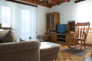 sala de estar con sofá, silla y TV en Apartments Ivančič, en Kobarid