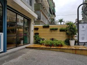 a store front with potted plants on a wooden porch at Little Apartment A+B Welcome Taipei Long Stay in Taipei