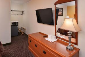 a room with a mirror and a lamp on a dresser at Red Carpet Inn Ronks in Ronks