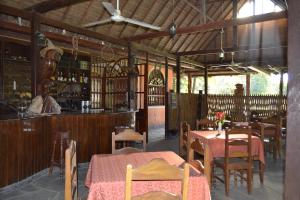 a restaurant with tables and chairs and a bar at La Isla de los Tucanes in Rurrenabaque