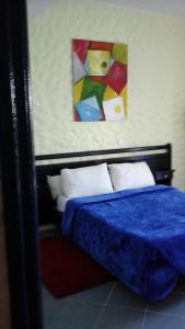 - une chambre dotée d'un lit bleu et d'une peinture murale dans l'établissement Thalassa, à Oualidia