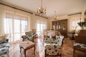 sala de estar con mesa y muebles de color azul y blanco en Villa Finella, en Penne