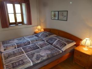 ライプニッツにあるFerienhaus Gründlのベッド1台(テーブルの上にランプ2つ付)