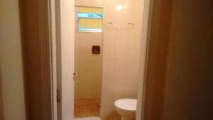 a bathroom with a toilet and a shower at Golfinho Hotel (Adults Only) in São Vicente