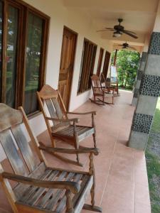 a row of rocking chairs sitting on a porch at La Perla in Pavones +13 photos