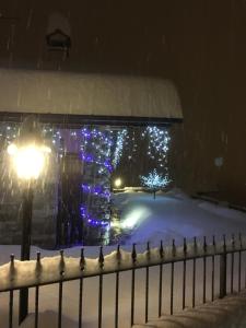 una casa coperta di luci nella neve di Appartamento Fleur Des Neiges ad Aosta