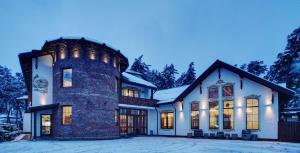 a home with a large brick tower at Shpatser hotel in Briukhovychi