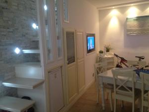 uma cozinha e sala de jantar com uma mesa e uma televisão em Sweet House em Cefalù