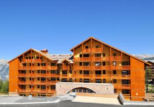 a large apartment building with a parking lot at T2 RESIDENCE ANTARES 4* pieds des pistes in Risoul