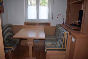 Zimmer mit einem Schreibtisch, einer Bank und einem Fenster in der Unterkunft Appartamento MaVi in Vals
