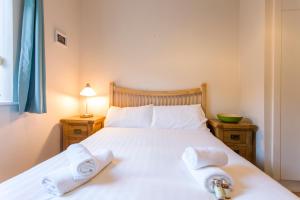 a bedroom with a white bed with towels on it at The Artane Self Catering in Dublin